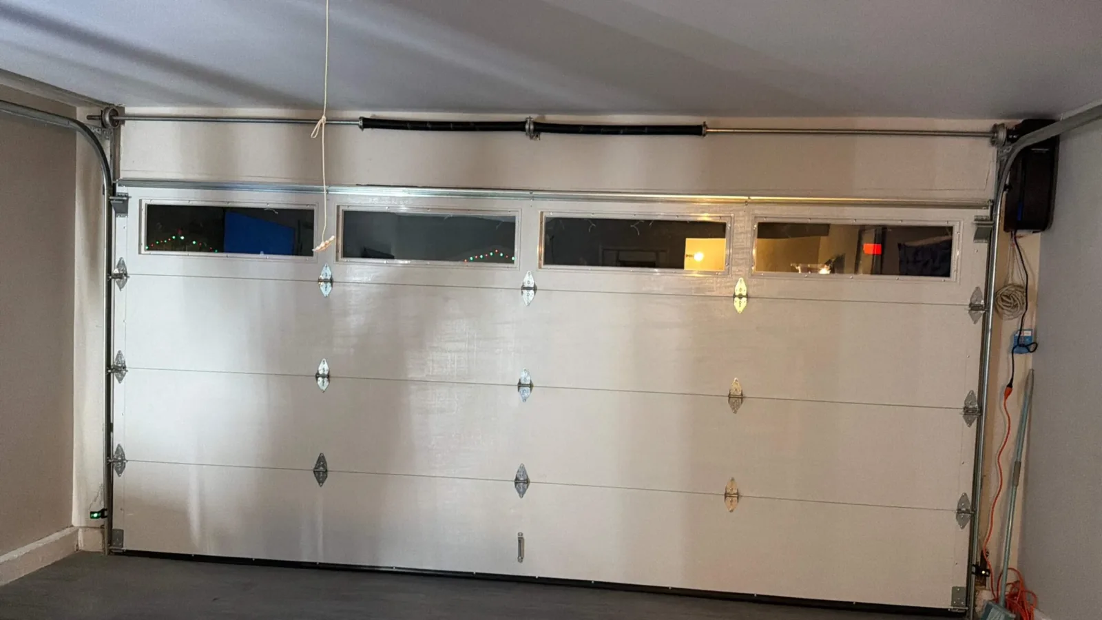 White sectional garage door with tinted window panels seen from inside